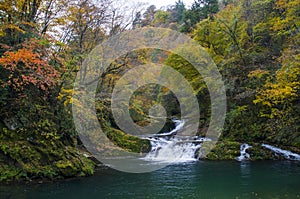 Small waterfall  in a valley in autumn photo