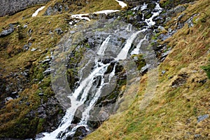 Small waterfall. Water falling on alpine rocks.