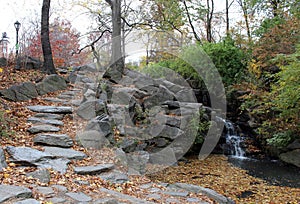 Small waterfalls line the path, in the middle of the central park