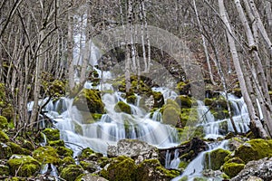 Small waterfalls running over moss-covered rocks