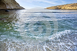 Small waves breaking in the Cala Blanca of crystal clear emerald green waters in the Puntas de Calnegre photo
