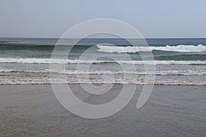 Small waves breaking on the sand of Fonte da Telha Beach, Portugal. photo