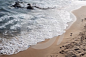 Small waves on the edge of a beach. Sunny day