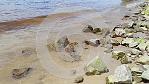 Small waves hit rocks on a beach