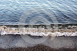 Small Waves Rolling on Dark Sand Beach