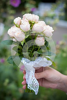 Small wedding bouquet of delicate roses in hands