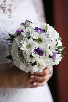 Small wedding bouquet in the hands of the bride
