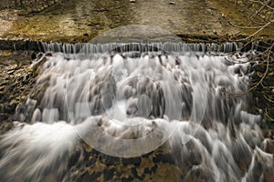 Small weir on Belca creek near bridge in Bohinjska Bistrica in Slovenia