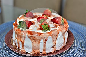 A small whipped cream cake with jam and strawberries decorating photo