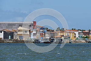 Small white and blue fishing boats and colorful buildings from the river`s or ferry`s point of view. Location Brejo Grande, Braz photo