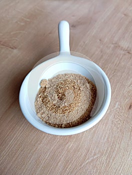 Small White Bowl With Stick Filled With Brown Crystallized Sugar