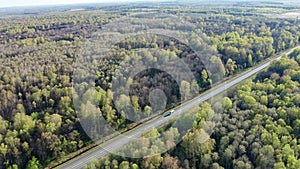 A small white bus with passengers at speed is on the highway. The concept of public transport and passenger transport