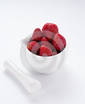 Small white china bowl filled with succulent juicy fresh ripe red strawberries