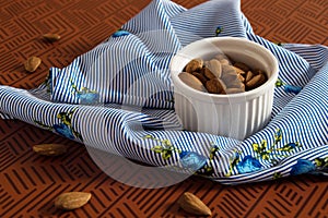 Small white container with shelled almonds