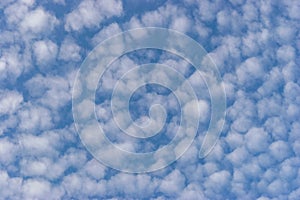 Small white cumulus clouds in blue sky