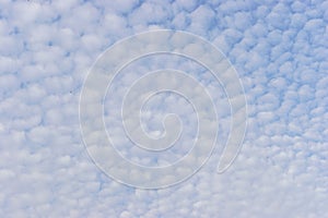 Small white cumulus clouds in blue sky