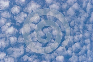 Small white cumulus clouds in blue sky