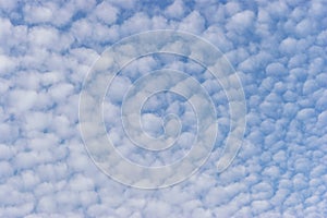 Small white cumulus clouds in blue sky