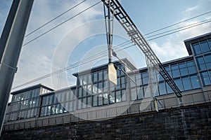 Small white empty sign on modern office building with glass exterior and cloudy sky background