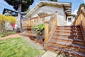 Small white house with deck and steps.