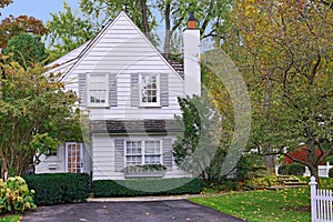 Small white house with gable and picket fence