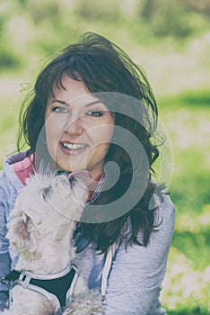 Small white maltese dog licking his owner