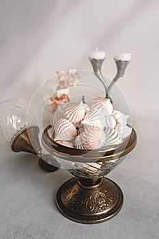 Small white meringues in a white dish on the table.