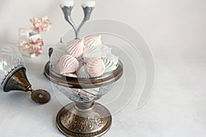 Small white meringues in a white dish on the table.