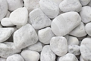 Small white pebbles, rocks, stones. Background/texture concept. Stones lying on top of each other in a pile.