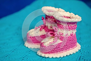 Small white-pink children`s knitted booties, hand-knitted