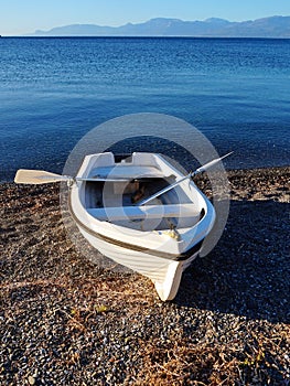 Small White Rowboat on Pebbly Bech