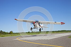 Small white single engine airplane takes off from a municipal airstrip in rural Minnesota