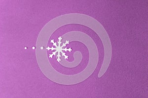 Small white snowflake and three little snowballs over violet background.Winter backdrop.