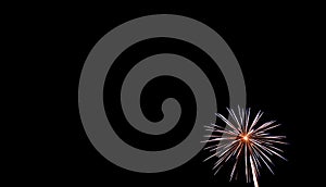 Small white starburst firework in lower right hand corner with black background