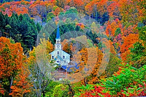 Small white steeple tucked away in the colorful green mountains HDR. photo