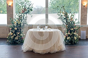 Small white table for two personas and beautiful floral wedding decorations photo