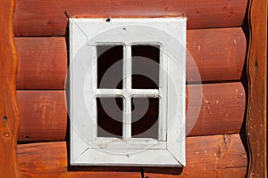 A small white window without glass in a wooden house for children