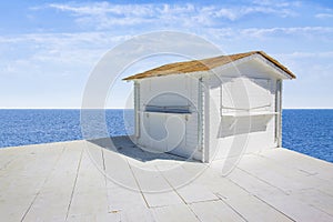 Small white wooden cottage with thatched roof by the sea - image with copy space