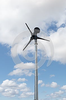 A Small wind turbine renewable energy source of future on blue sky with cloud as background