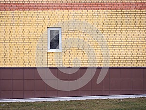 A small window in a brick wall. Colored bricks