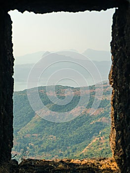 A Small Window Frame Of An Indian Fort With The View oF Mountain Range