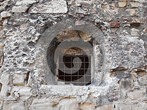 Small window with gride in stone wall