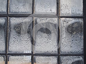 Small window panes with ice and frost in winter