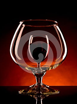 Small wineglass is visible through a large glass of wine