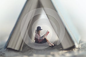 Small woman reading a book law protected by a house made from a giant book photo