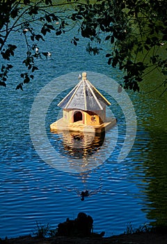 Small wooden birdhouse in the middle of a lake