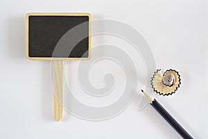 Small wooden blackboard with a pencil and pencil shavings isolated on white background