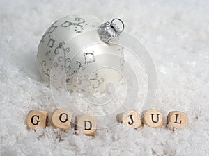 Small wooden blocks with the Scandinavian inscription Merry Christmas in the snow