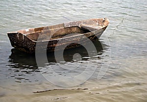 Small wooden boat anchored on the beach