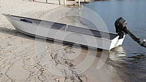 Small wooden boat attach with motor engine parking at the beach